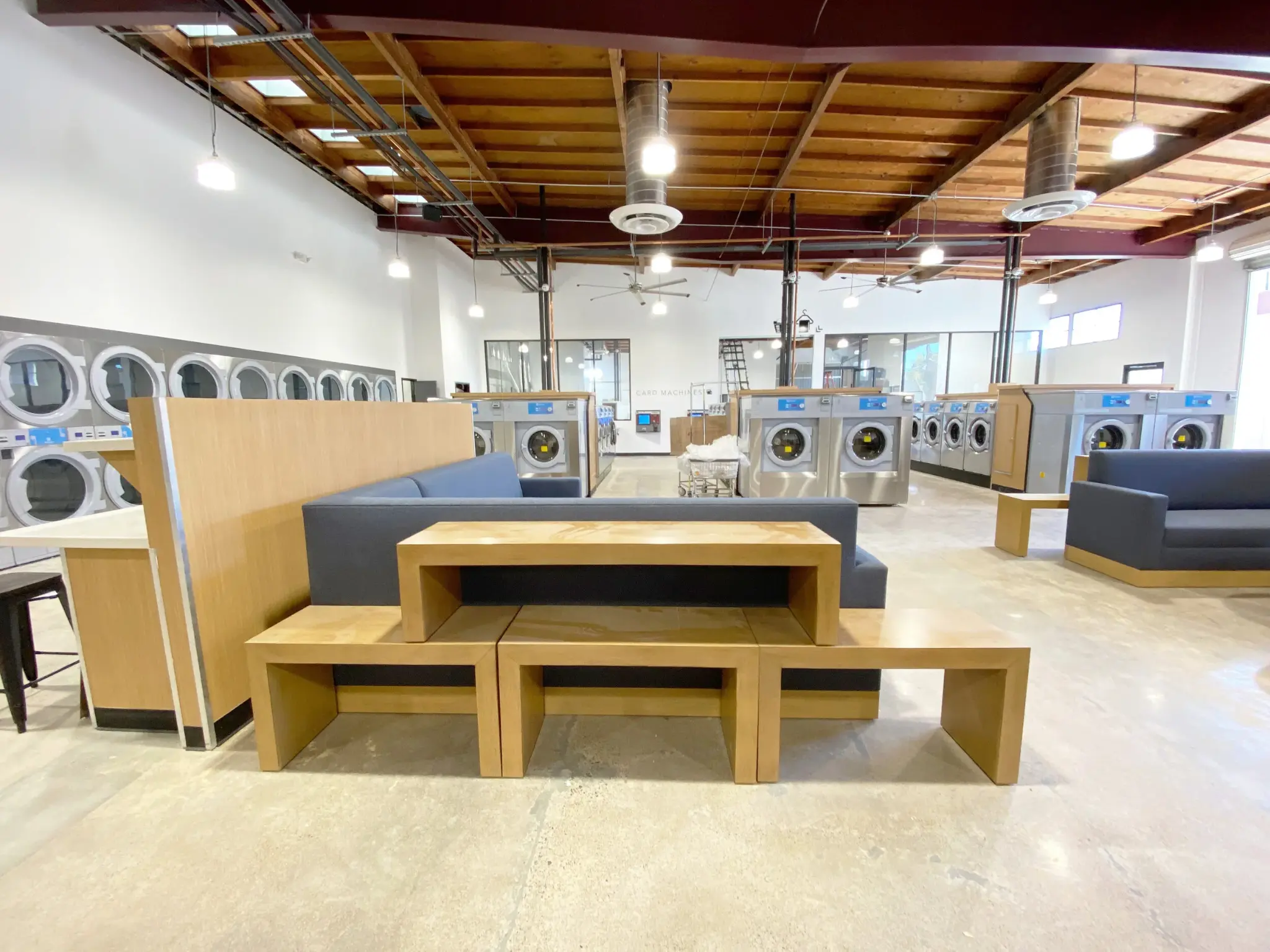 Wide interior view of Lucy's Laundry Costa Mesa with high ceilings and rows of washers